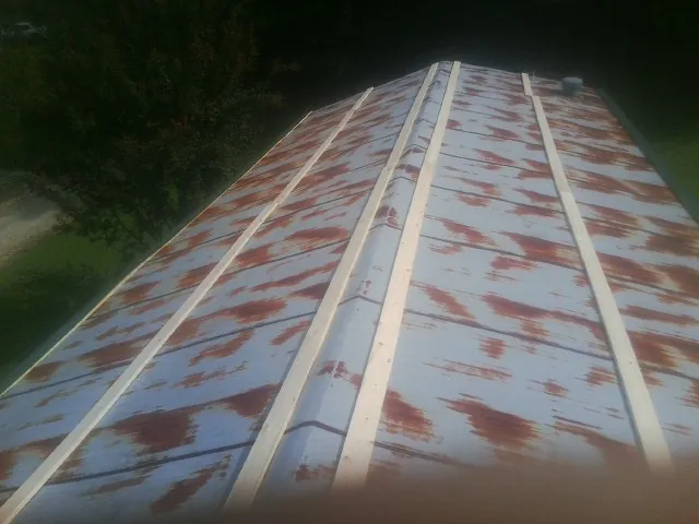 Rusted metal roof panels with new wood purlins before replacement — Storm Damage Roof Repair in Lake Alfred by Roofing Brothers