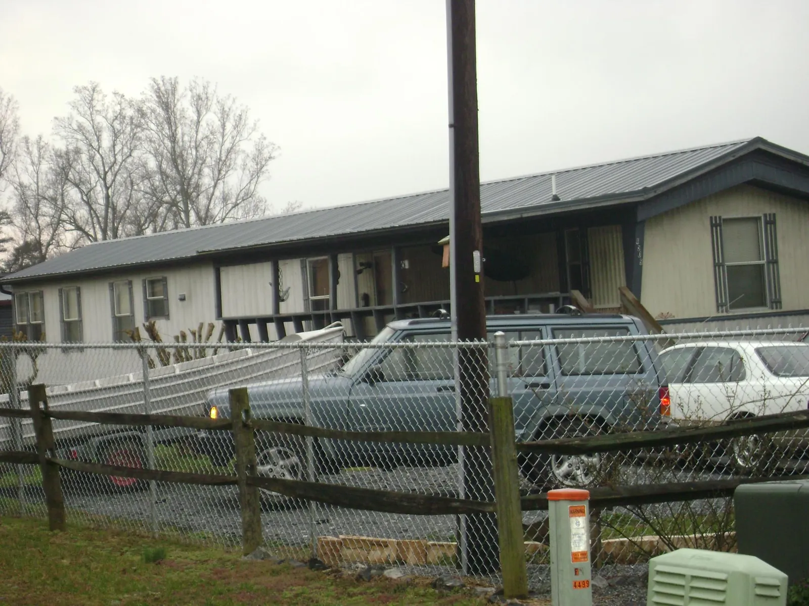 Dark metal roof on a long single story building behind a chain link fence in Lake Alfred